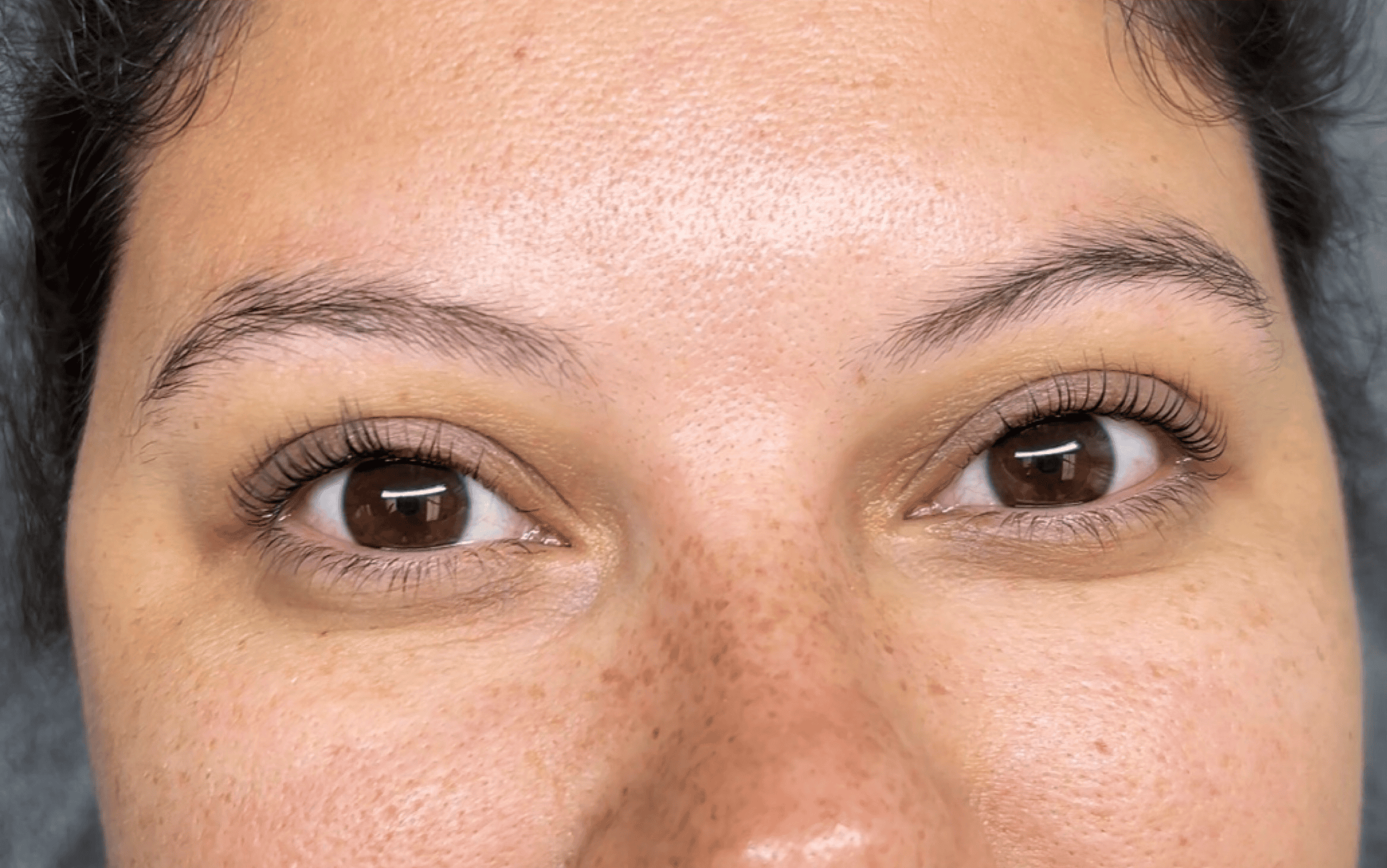 The same eye after a Korean lash lift and tint, lifted at the base and darker